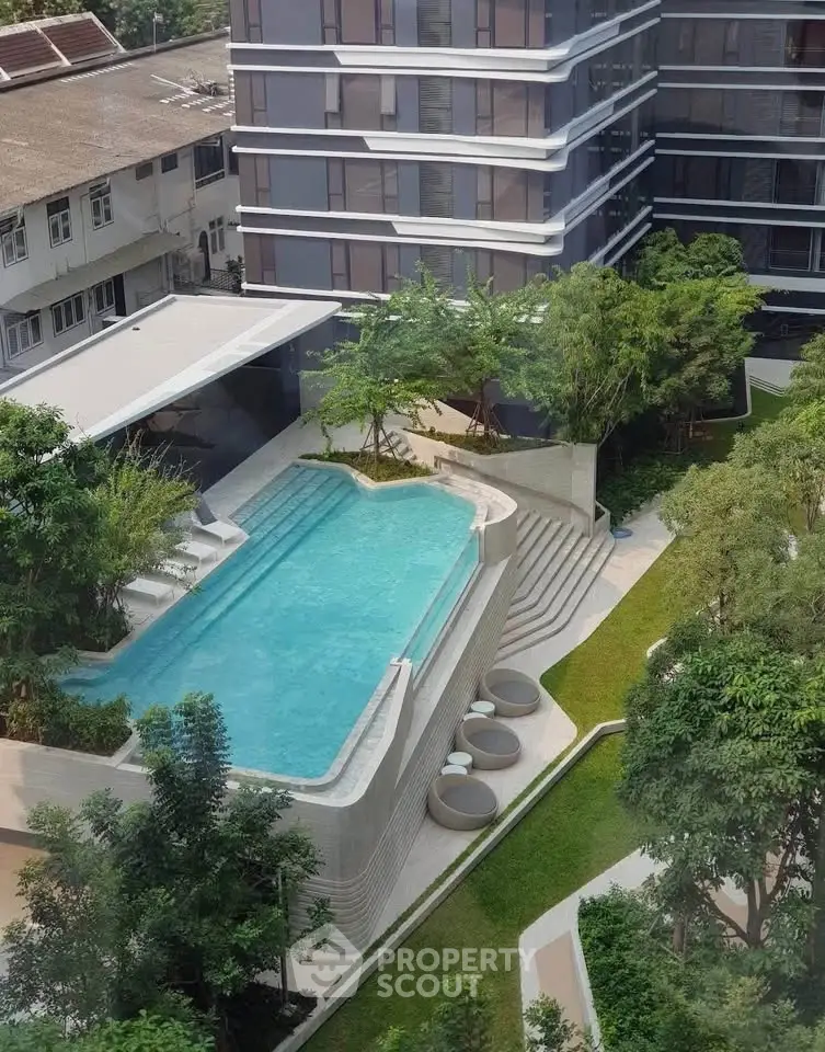 Luxurious apartment complex with modern pool and lush garden view