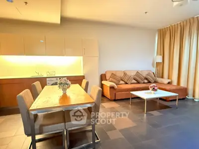 Spacious living room with modern kitchen and cozy seating area, perfect for entertaining guests.