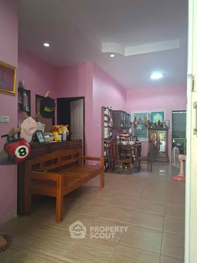 Charming pink-themed living room with wooden furniture and decorative accents.