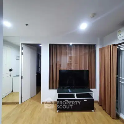 Modern living room with sleek TV stand and wooden flooring in a stylish apartment.
