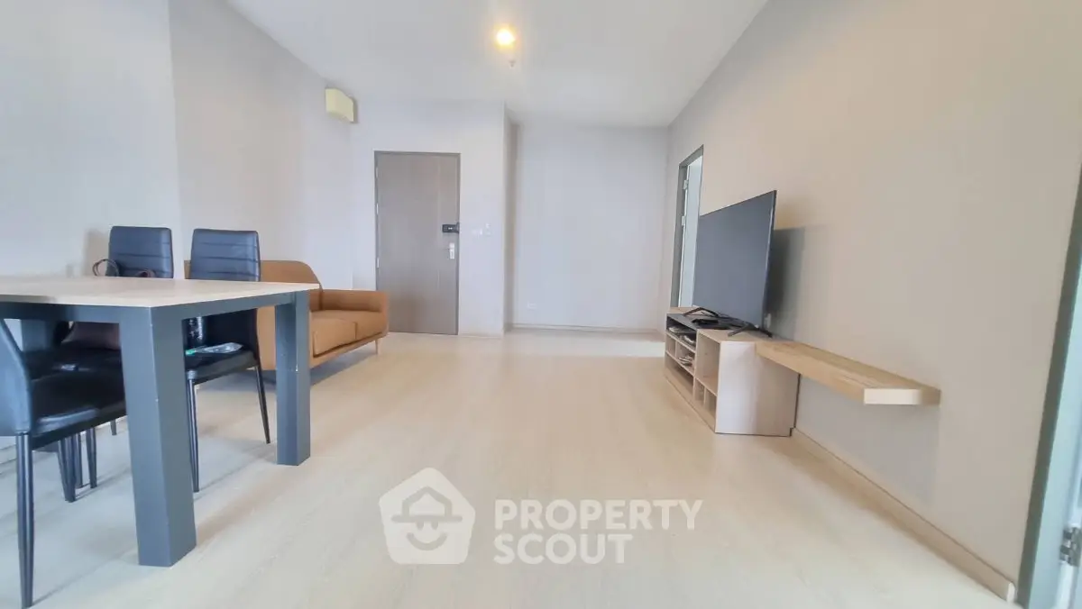 Spacious modern living room with sleek furniture and large TV setup.
