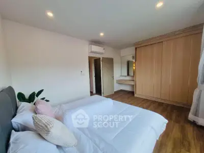 Spacious bedroom with modern decor and wooden flooring