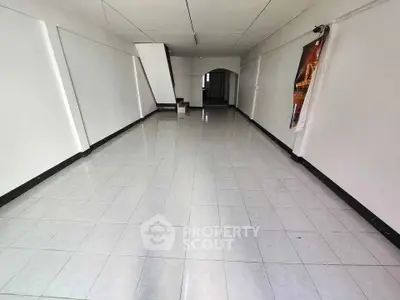 Spacious empty room with tiled flooring and white walls, ideal for customization.