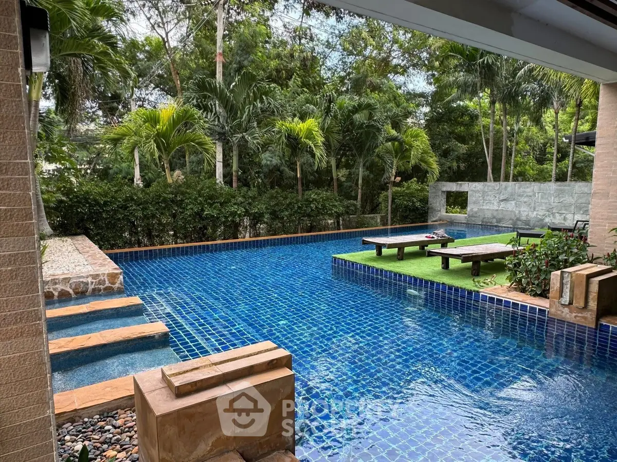 Luxurious outdoor pool area with lush greenery and modern design, perfect for relaxation and entertainment.
