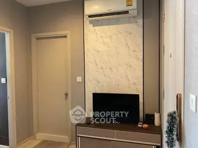 Modern living room with air conditioning and TV unit, featuring stylish decor and neutral tones.