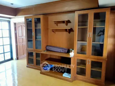Spacious living room with elegant wooden cabinetry and ample natural light.