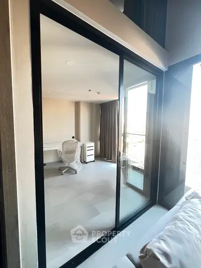 Modern study room with glass sliding doors and sleek furniture in a bright apartment