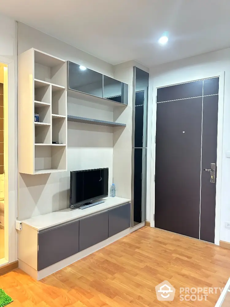 Modern living room with sleek TV unit and wooden flooring