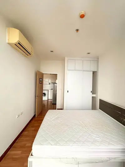 Spacious bedroom with built-in wardrobe and air conditioning in modern apartment