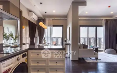 Modern open-plan living room with kitchen and balcony view