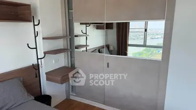 Modern bedroom with mirrored wardrobe and city view, featuring sleek wooden shelves and cozy bedding.