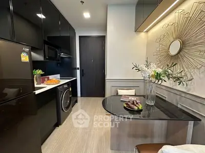 Modern kitchen with sleek black cabinets, integrated appliances, and stylish decor