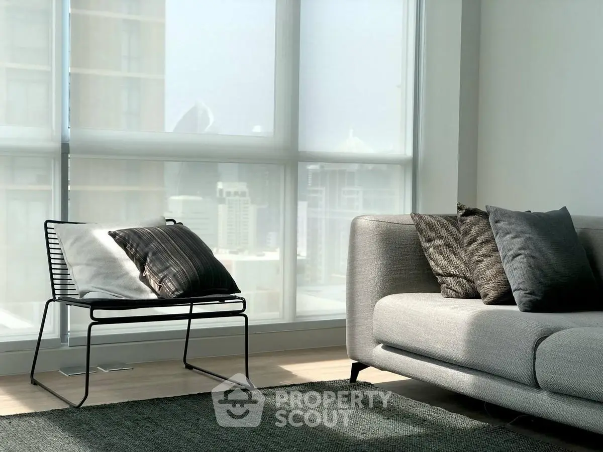 Modern living room with stylish furniture and city view through large windows.