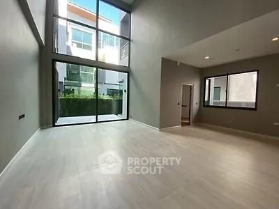 Spacious modern living room with large windows and high ceiling