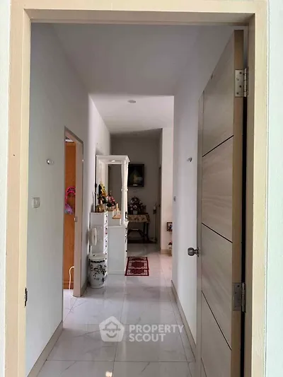 Bright hallway with modern decor and white tiled flooring in a contemporary home.