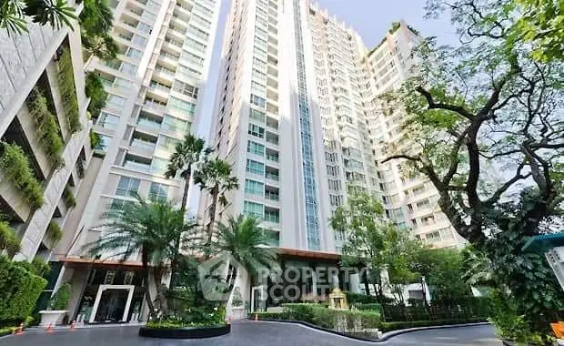 Luxurious high-rise condominium with lush greenery and modern architecture.