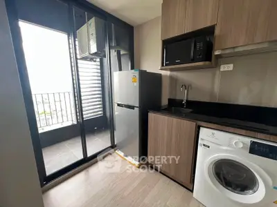 Modern kitchen with appliances and balcony view in stylish apartment