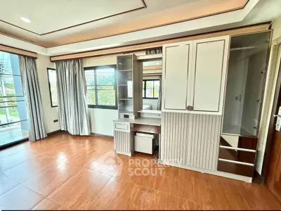 Spacious bedroom with built-in wardrobe and large windows offering natural light.