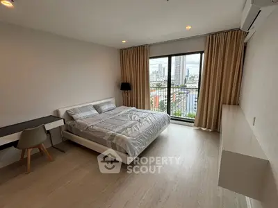 Spacious modern bedroom with city view, featuring sleek furniture and large windows for natural light.