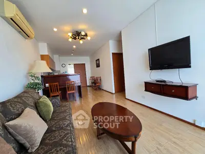 Spacious living room with modern decor and wall-mounted TV in a stylish apartment.