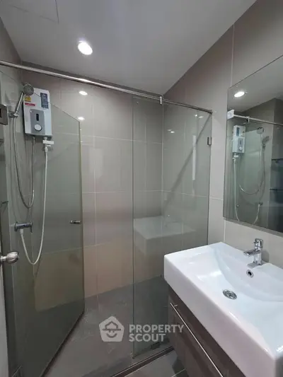 Modern bathroom with glass shower enclosure and sleek sink design