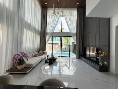 Luxurious modern living room with high ceilings, elegant decor, and pool view, perfect for upscale living.