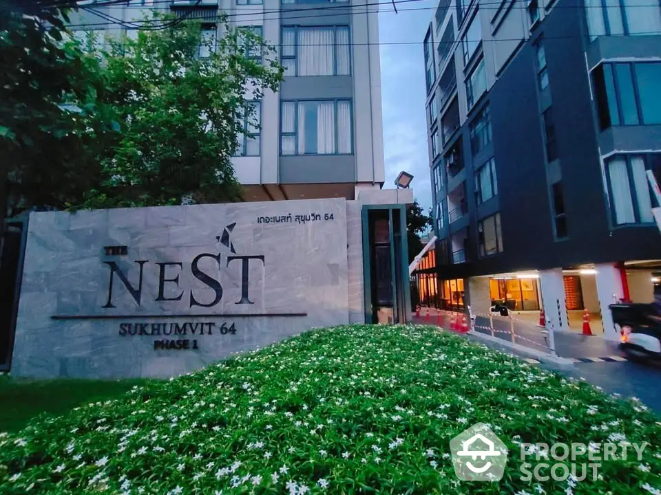 Modern condominium entrance with lush greenery at The Nest Sukhumvit 64 Phase 1