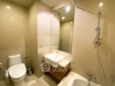 Modern bathroom with sleek fixtures and neutral tones, featuring a bathtub and shower combination.