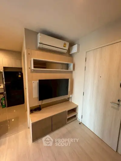 Modern living room with sleek TV setup and air conditioning unit