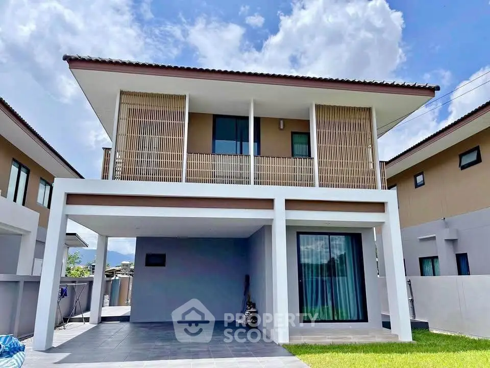 Modern two-story house with spacious carport and stylish balcony design.