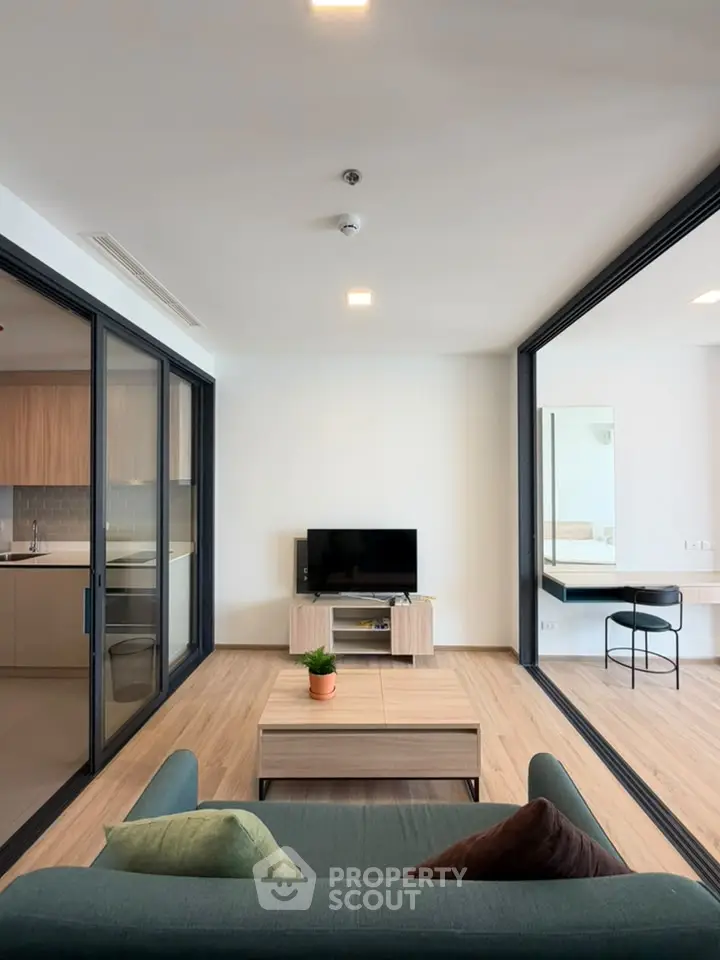 Modern living room with sleek design and open layout, featuring a cozy sofa and stylish decor.