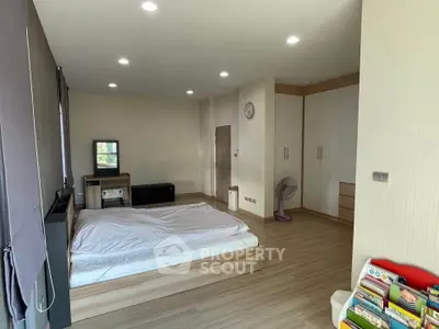 Spacious bedroom with modern decor and ample natural light, featuring a cozy bed and stylish storage solutions.