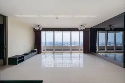 Spacious living room with floor-to-ceiling windows and stunning city view