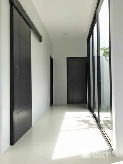 Modern hallway with sleek sliding doors and large windows