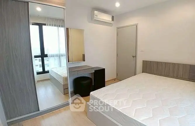 Modern bedroom with large window and stylish furniture in a bright apartment.