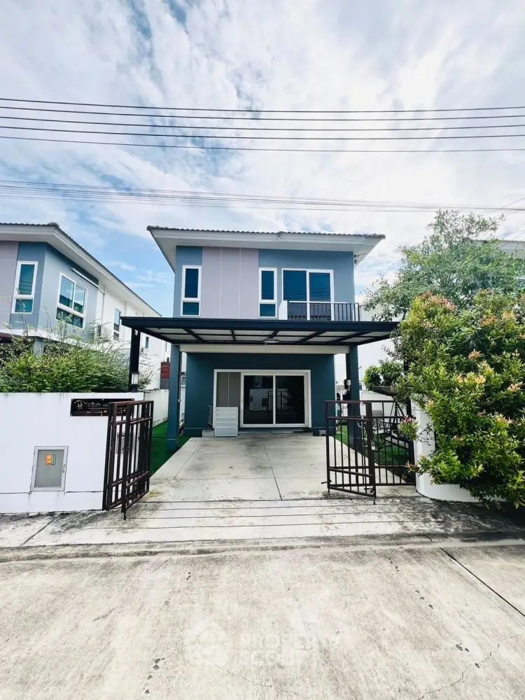 Modern two-story house with driveway and lush greenery, perfect for family living.