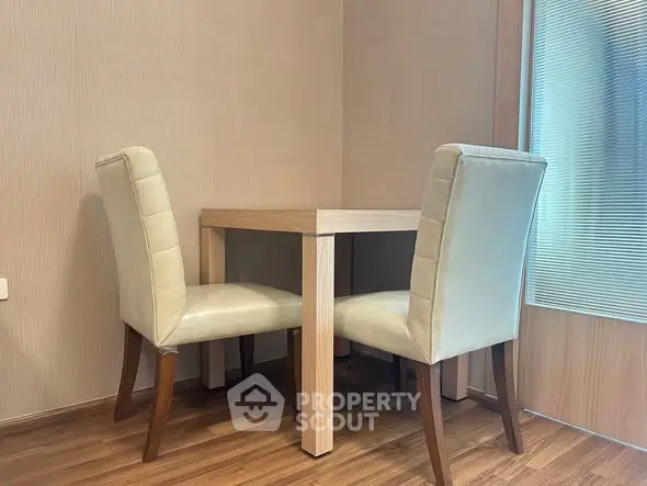 Cozy dining nook with elegant chairs and wooden table in modern apartment.