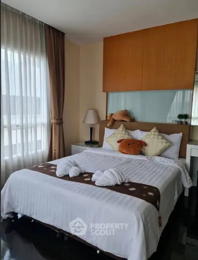 Cozy bedroom with plush bedding and natural light, perfect for relaxation.