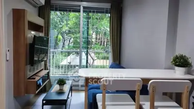 Modern living room with balcony view, featuring sleek furniture and natural light.