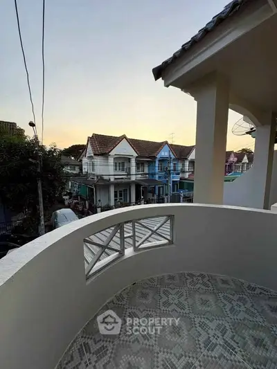 Charming balcony view of quaint neighborhood houses at sunset, perfect for relaxing evenings.