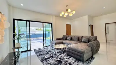 Spacious modern living room with large windows and stylish furniture in a bright, open layout.