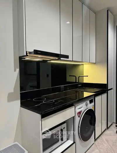 Modern kitchen with sleek cabinetry, integrated appliances, and stylish black countertops.
