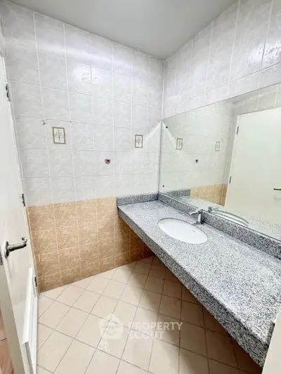 Spacious bathroom with elegant granite countertop and modern fixtures.