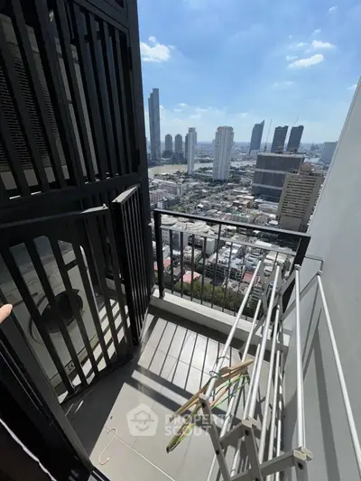 Stunning city view from a high-rise balcony with modern railing and ample sunlight.