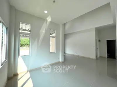 Spacious modern living room with high ceilings and large windows for natural light.