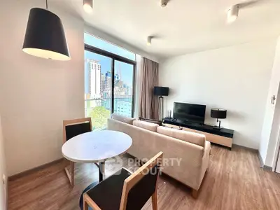 Modern living room with city view, featuring stylish furniture and large windows for natural light.