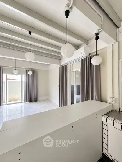Modern living room with stylish pendant lights and large windows