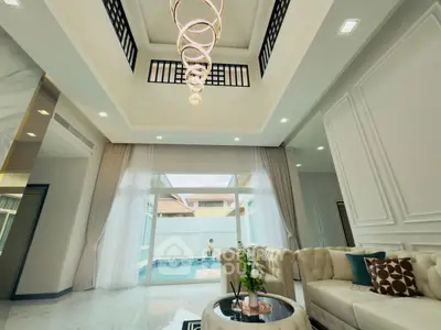Luxurious living room with high ceiling and pool view, featuring elegant decor and modern lighting.