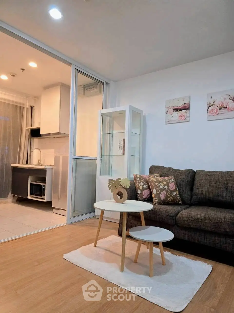 Modern living room with cozy sofa and open kitchen layout in stylish apartment.