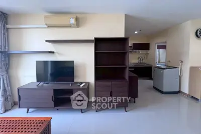 Modern living room with sleek furniture and open kitchen layout in a stylish apartment.